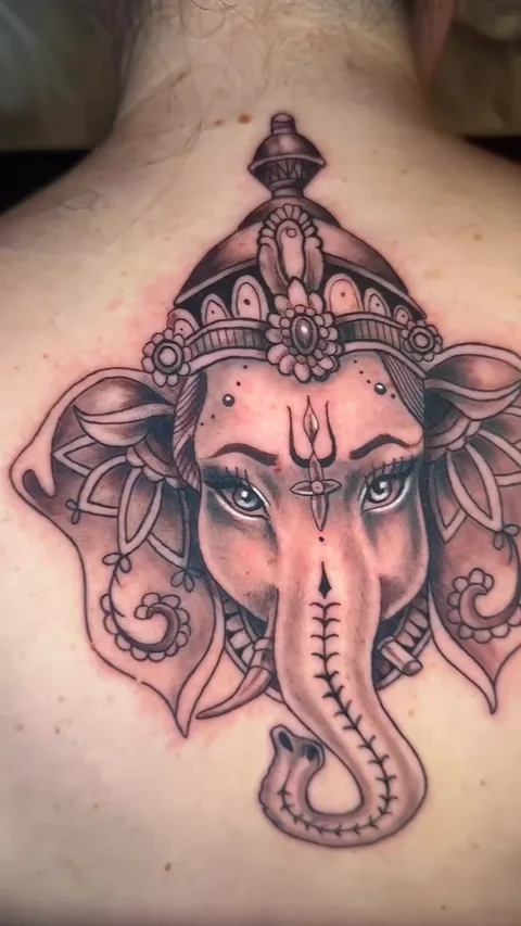 Tatuaje de ganesha recién hecho en espalda, realismo